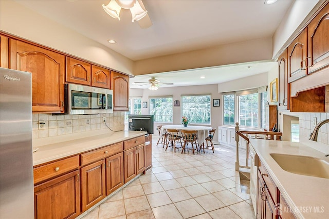64 Annette Dr, Edison, NJ 08820 - kitchen with stainless steel appliances, ceiling fan, tasteful backsplash, brown cabinetry, and light countertops