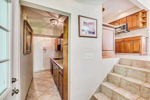 64 Annette Dr, Edison, NJ 08820 - kitchen featuring stainless steel microwave, light countertops, brown cabinetry, and light tile patterned floors