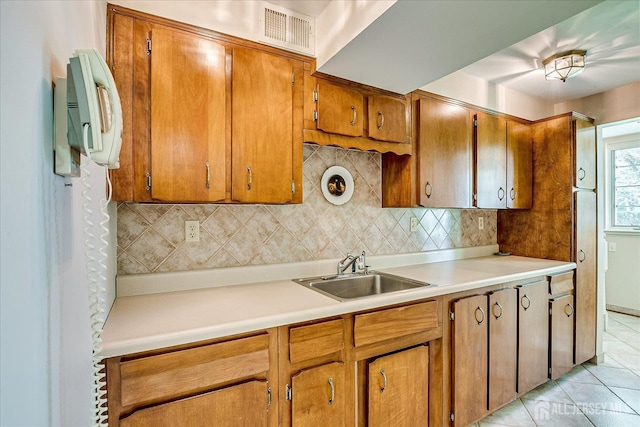 64 Annette Dr, Edison, NJ 08820 - kitchen featuring decorative backsplash, brown cabinets, light countertops, and light tile patterned floors