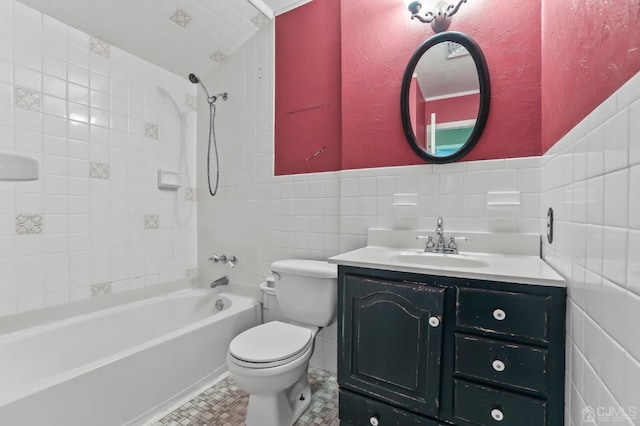 full bathroom with tile patterned floors, toilet, tiled shower / bath, tile walls, and vanity