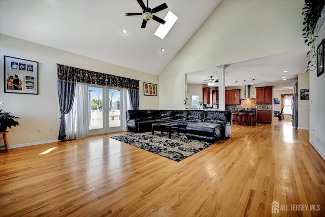 2 Eddie Ct, South Brunswick, NJ 08810 - living room with ceiling fan, a skylight, light wood-style flooring, high vaulted ceiling, and baseboards