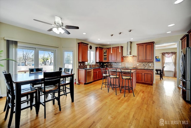 2 Eddie Ct, South Brunswick, NJ 08810 - kitchen featuring wall chimney range hood, appliances with stainless steel finishes, dark countertops, a sink, and a center island