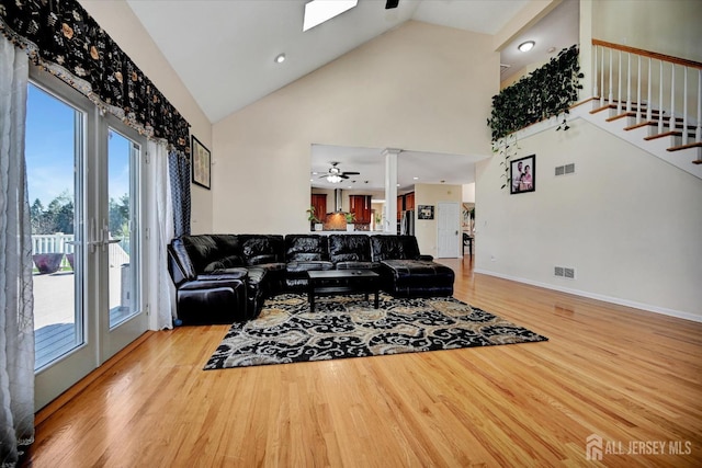 2 Eddie Ct, South Brunswick, NJ 08810 - living area with high vaulted ceiling, wood finished floors, stairway, a ceiling fan, and a skylight