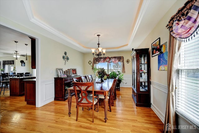 2 Eddie Ct, South Brunswick, NJ 08810 - dining room with a chandelier, a tray ceiling, light wood-style flooring, a decorative wall, and wainscoting