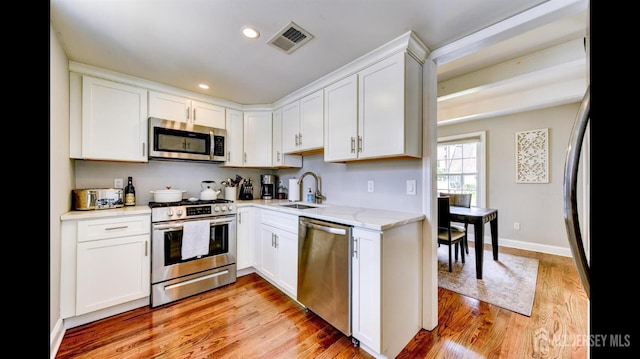 3 Mayfield Pl, Metuchen, NJ 08840 - kitchen with stainless steel appliances, white cabinetry, light wood-type flooring, recessed lighting, and light stone countertops
