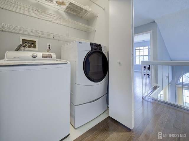 laundry area with washer and clothes dryer, laundry area, and wood finished floors