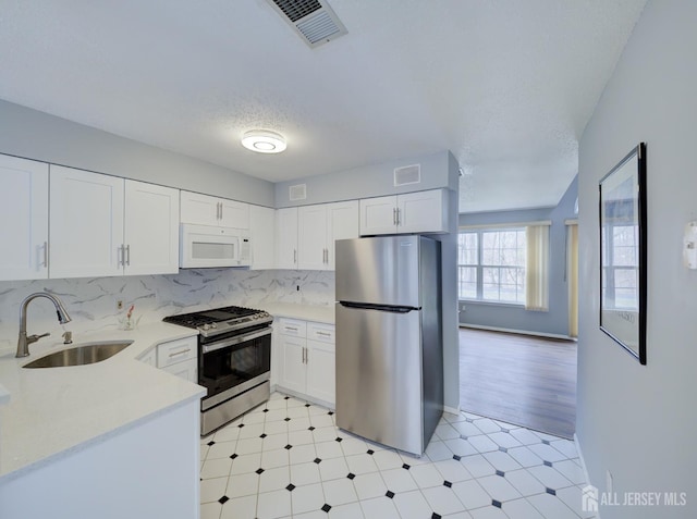 kitchen featuring a sink, visible vents, light floors, and appliances with stainless steel finishes