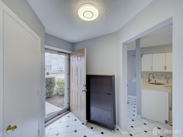 entryway featuring light floors and a textured ceiling