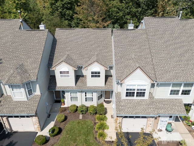 view of front of home with aphalt driveway, a garage, and roof with shingles