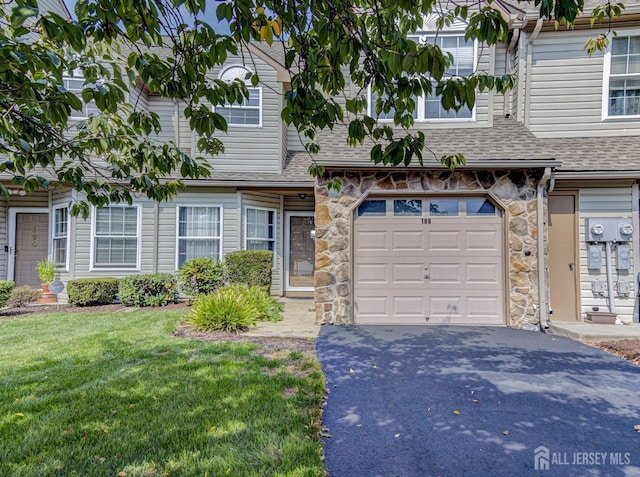 multi unit property with aphalt driveway, stone siding, an attached garage, and a shingled roof