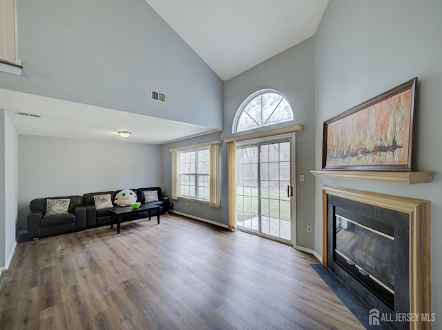 living room with visible vents, a fireplace with flush hearth, and wood finished floors