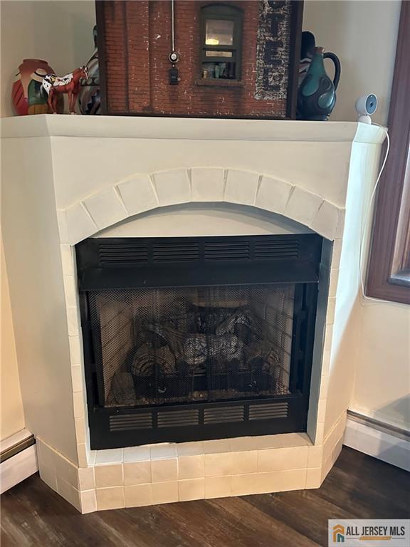 5 Serviss Ave, East Brunswick, NJ 08816 - detailed view of a fireplace, wood finished floors, and a baseboard radiator