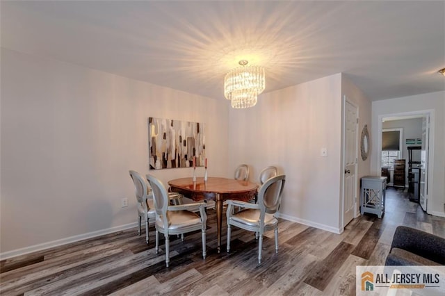 dining room with baseboards, an inviting chandelier, and wood finished floors