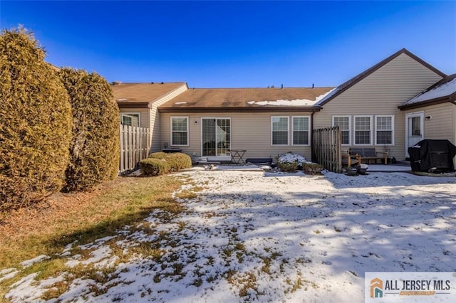 snow covered property featuring a patio and fence