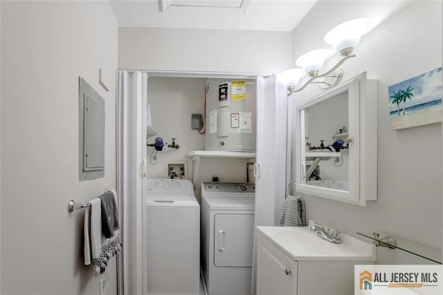 laundry area with a sink, electric panel, washing machine and dryer, and electric water heater