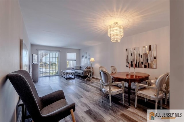 dining space featuring wood finished floors and a chandelier