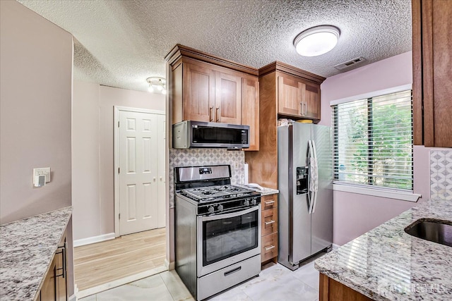19 Carriage Pl, Edison, NJ 08820 - kitchen with stainless steel appliances, a textured ceiling, tasteful backsplash, light stone countertops, and brown cabinetry
