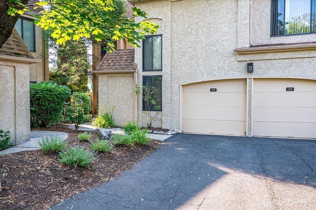 19 Carriage Pl, Edison, NJ 08820 - view of front facade with stucco siding, an attached garage, and driveway