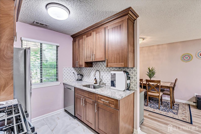 19 Carriage Pl, Edison, NJ 08820 - kitchen featuring stainless steel appliances, a textured ceiling, tasteful backsplash, light stone countertops, and brown cabinets