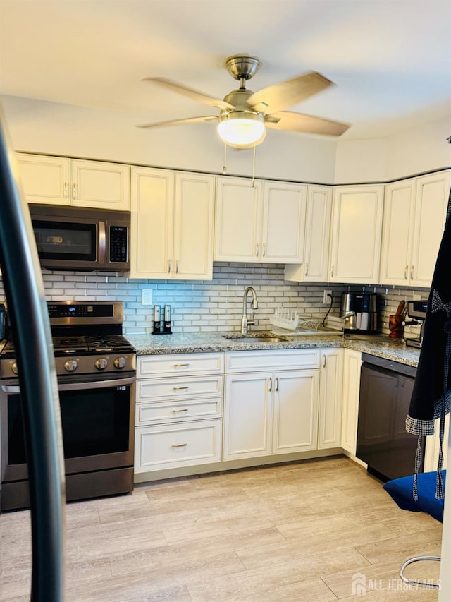 45 Marina View Dr, Sewaren, NJ 07077 - kitchen featuring appliances with stainless steel finishes, a ceiling fan, decorative backsplash, and light stone counters