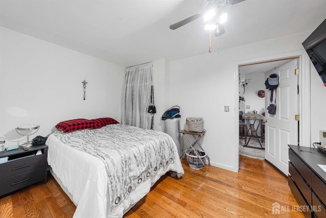 bedroom featuring ceiling fan, light wood-style flooring, and baseboards