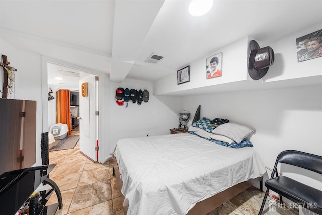 bedroom with visible vents and stone tile floors