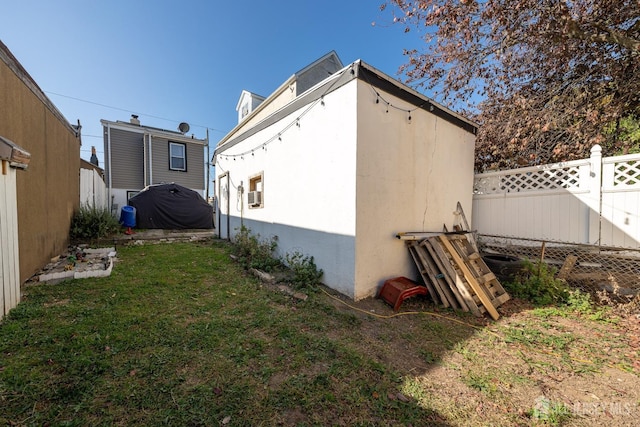 view of property exterior featuring fence private yard, a lawn, and stucco siding