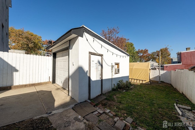 garage featuring fence and driveway