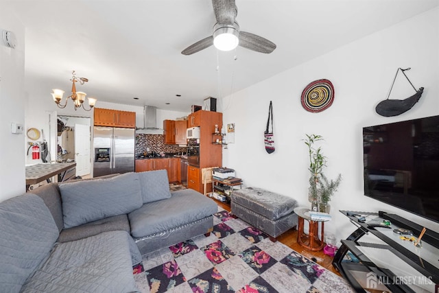 living room with wood finished floors and ceiling fan with notable chandelier