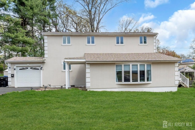 back of property featuring roof with shingles, an attached garage, aphalt driveway, stucco siding, and a lawn
