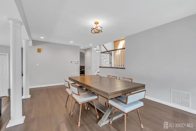 dining area featuring visible vents, decorative columns, wood finished floors, baseboards, and stairway