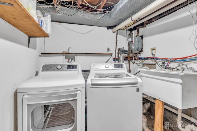 laundry area with laundry area, a sink, and washer and clothes dryer