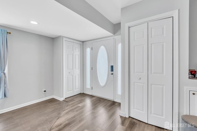 entryway with baseboards and wood finished floors