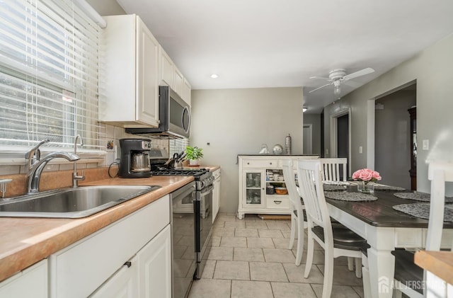 1565 W 6th St, Piscataway, NJ 08854 - kitchen featuring stainless steel appliances, white cabinets, ceiling fan, decorative backsplash, and light countertops