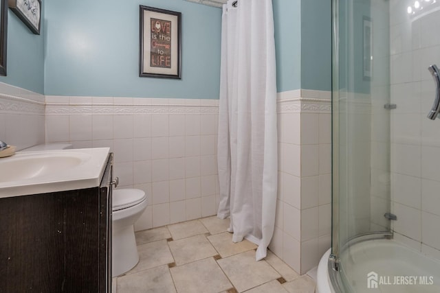 1565 W 6th St, Piscataway, NJ 08854 - bathroom featuring tile walls, vanity, wainscoting, shower / bathtub combination with curtain, and tile patterned floors