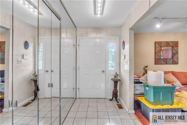 entryway featuring baseboards and light tile patterned floors