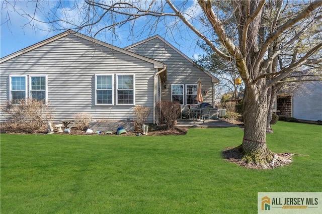 back of property with a lawn and a patio area