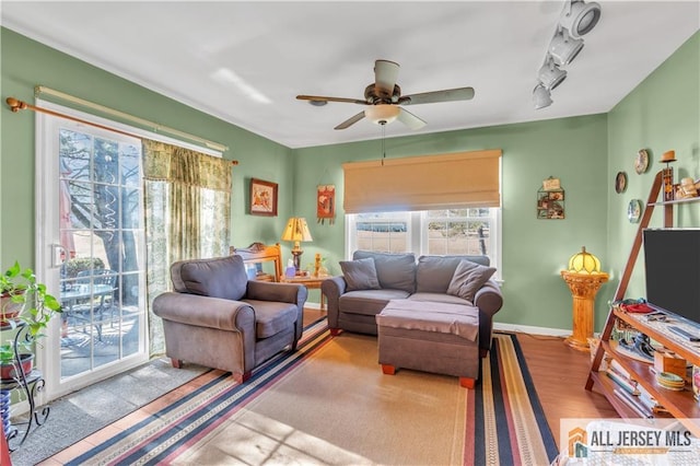 living room with light wood-type flooring, ceiling fan, and rail lighting