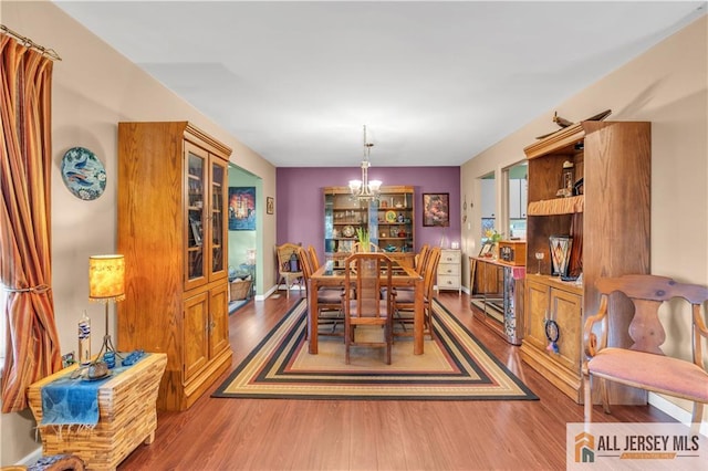 dining space with hardwood / wood-style flooring and a chandelier