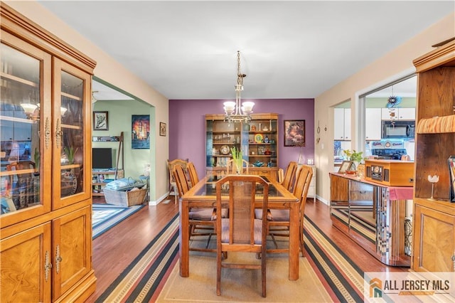 dining room with light hardwood / wood-style floors and an inviting chandelier