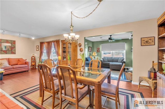 dining area with an inviting chandelier, wood-type flooring, and a healthy amount of sunlight