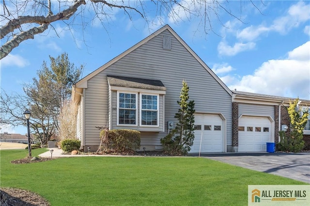 view of side of home with driveway, a yard, crawl space, and an attached garage