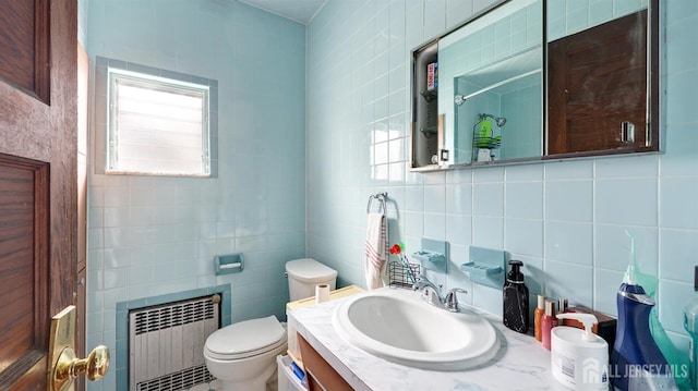 full bathroom featuring vanity, toilet, radiator, tile walls, and backsplash