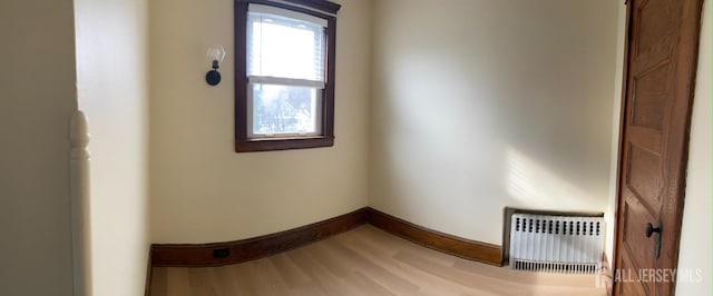 interior space featuring baseboards, heating unit, and light wood finished floors