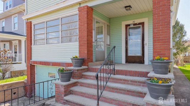 property entrance with an attached garage and covered porch