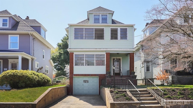 traditional style home with roof with shingles, an attached garage, and concrete driveway
