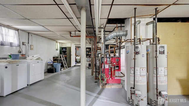 basement with water heater, concrete block wall, and washing machine and clothes dryer