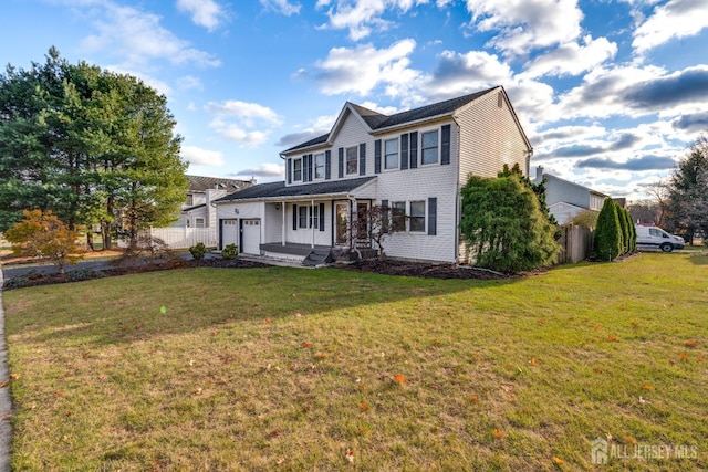 view of front of property featuring a garage, a front lawn, and covered porch