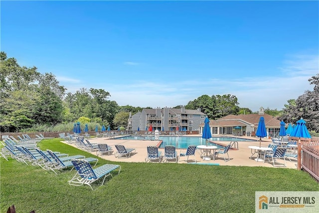 pool featuring a patio, a lawn, and fence