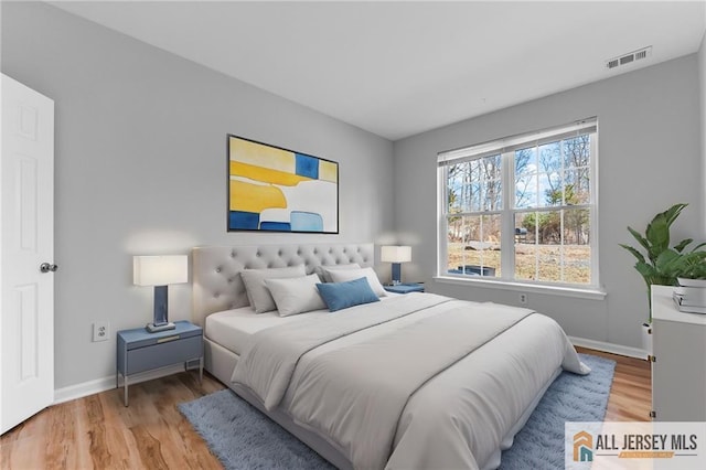 bedroom featuring visible vents, baseboards, and light wood-style flooring